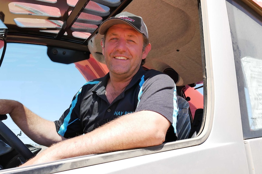 A smiling Ross Stone sitting in the cab of a truck.