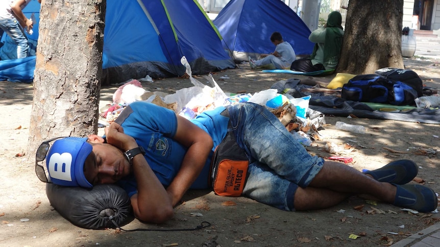 An asylum seeker sleeps in a park in Belgrade