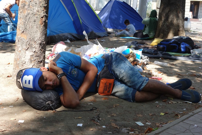 An asylum seeker sleeps in a park in Belgrade