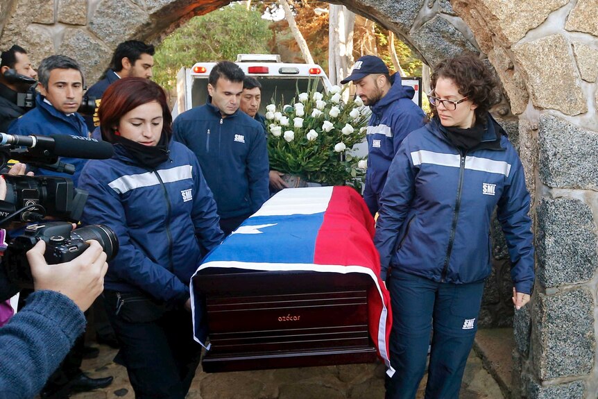 Forensic legal service staff carry the coffin of Chilean poet and Nobel laureate Pablo Neruda which is draped in flag