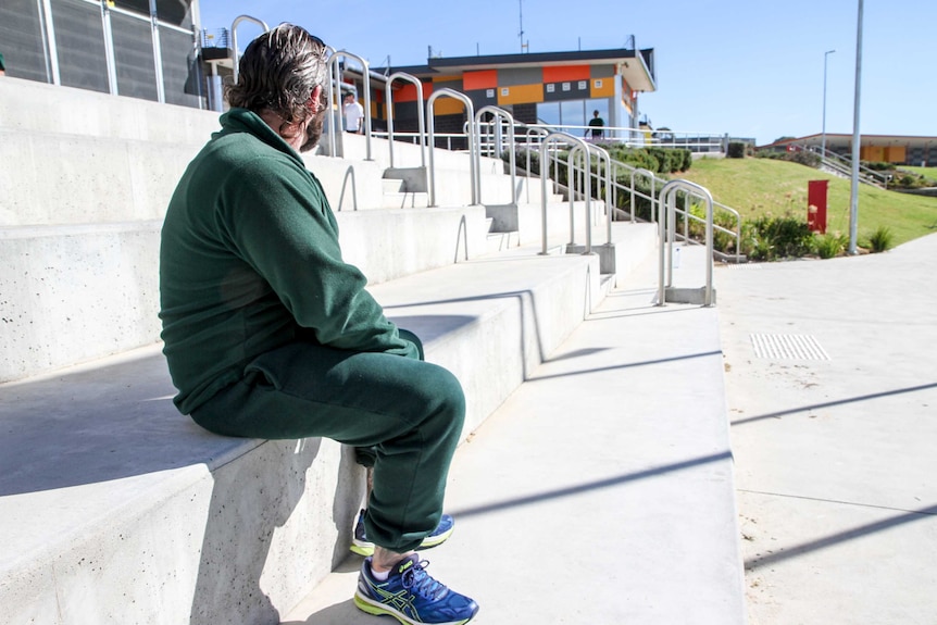 Prisoner sitting on steps in quadrant.