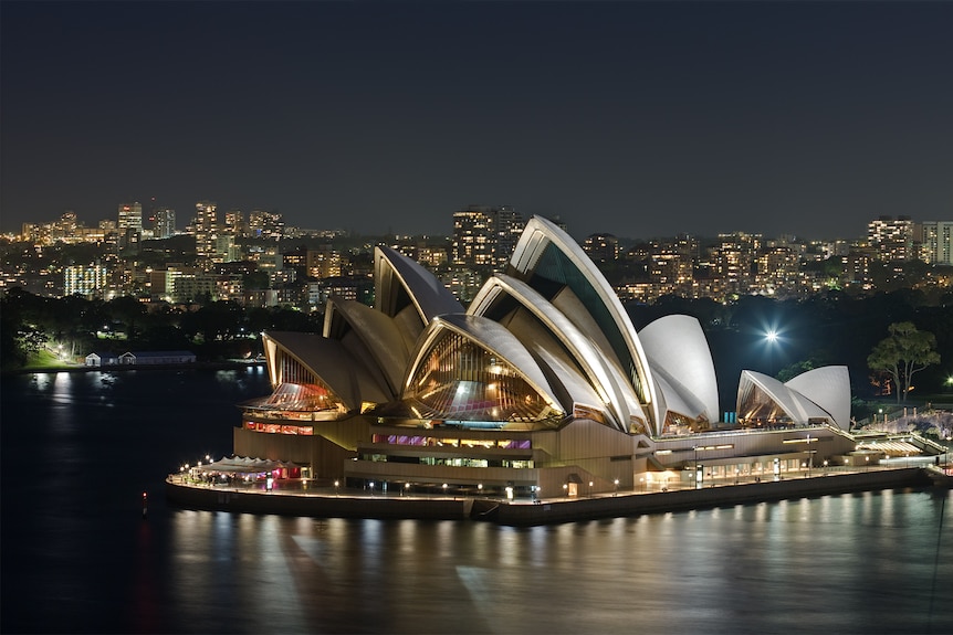 Sydney Opera House lit up at night.