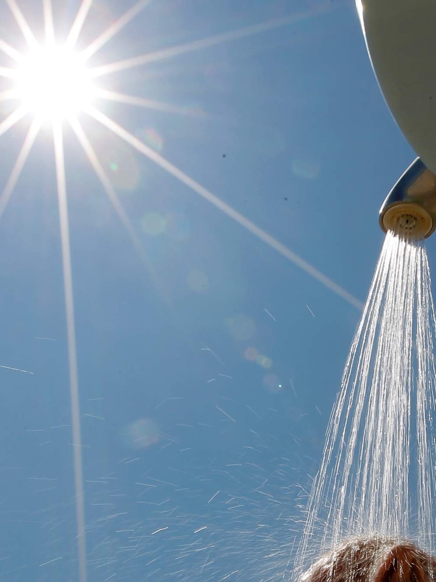 Man takes a cold shower on a beach