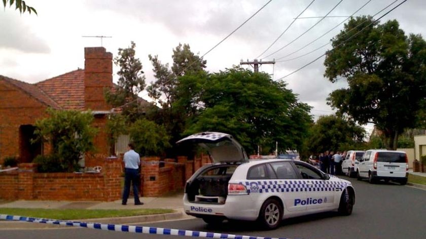 Police stand outside a house at Field Street in Bentleigh