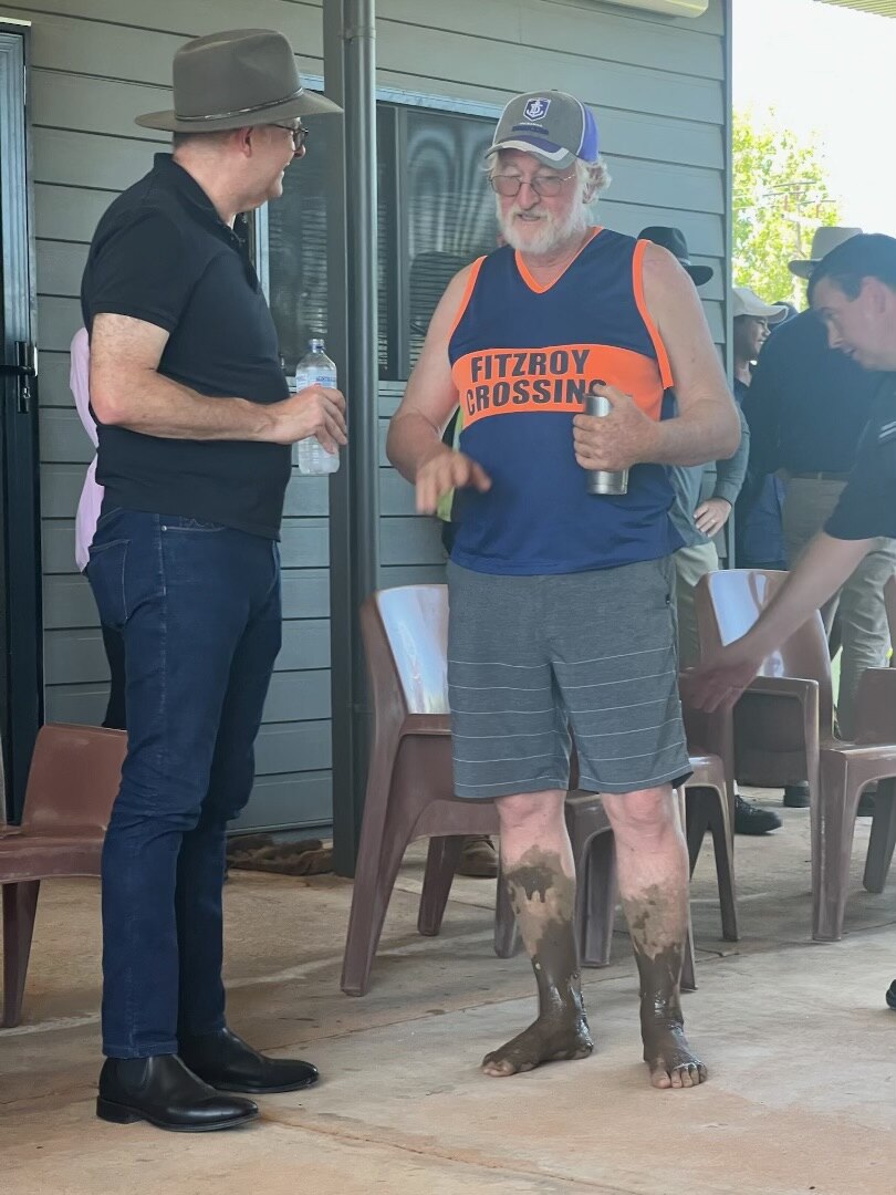 Geoff Davis with muddy feet talking to Anthony Albanese in Fitzroy Crossing, January 2023.