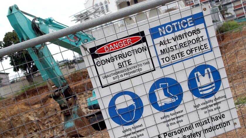 A 'Workplace Health and Safety Induction' sign hangs on the fence of a building site in Brisbane in December, 2007.