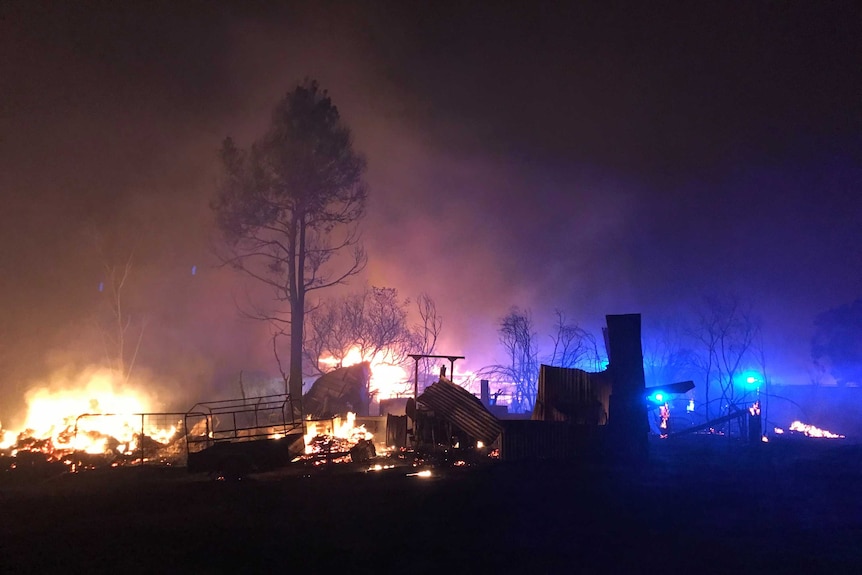 At night, a large fire burns down a house on a farm