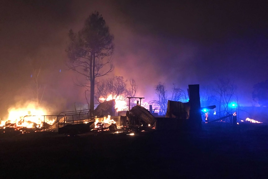 At night, a large fire burns down a house on a farm