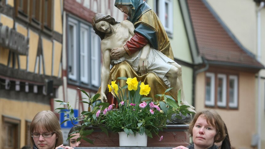 Members of different craftsmen guilds carry a sculpture from the Way of the Cross during a Good Friday procession.