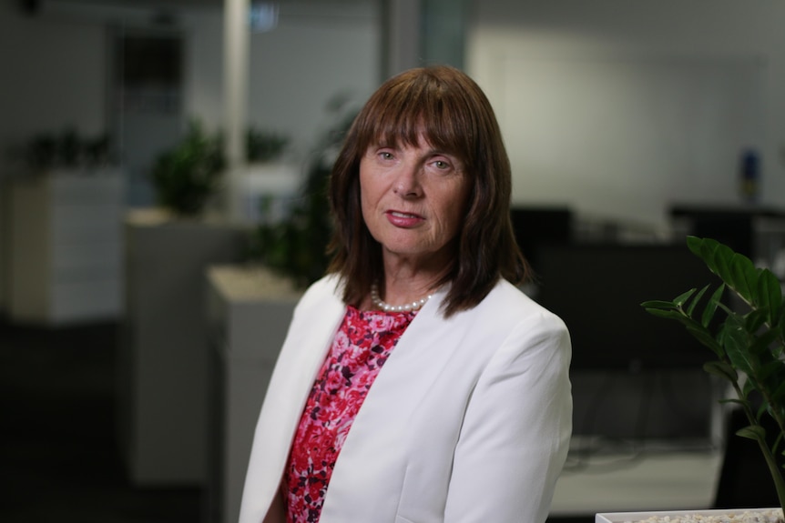 A woman in a white blazer sitting in an office