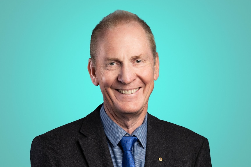 A man in blue shirt and black suit. 