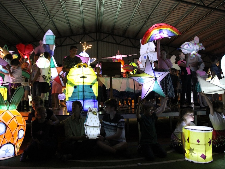 Hand-made character lanterns held by students and teachers