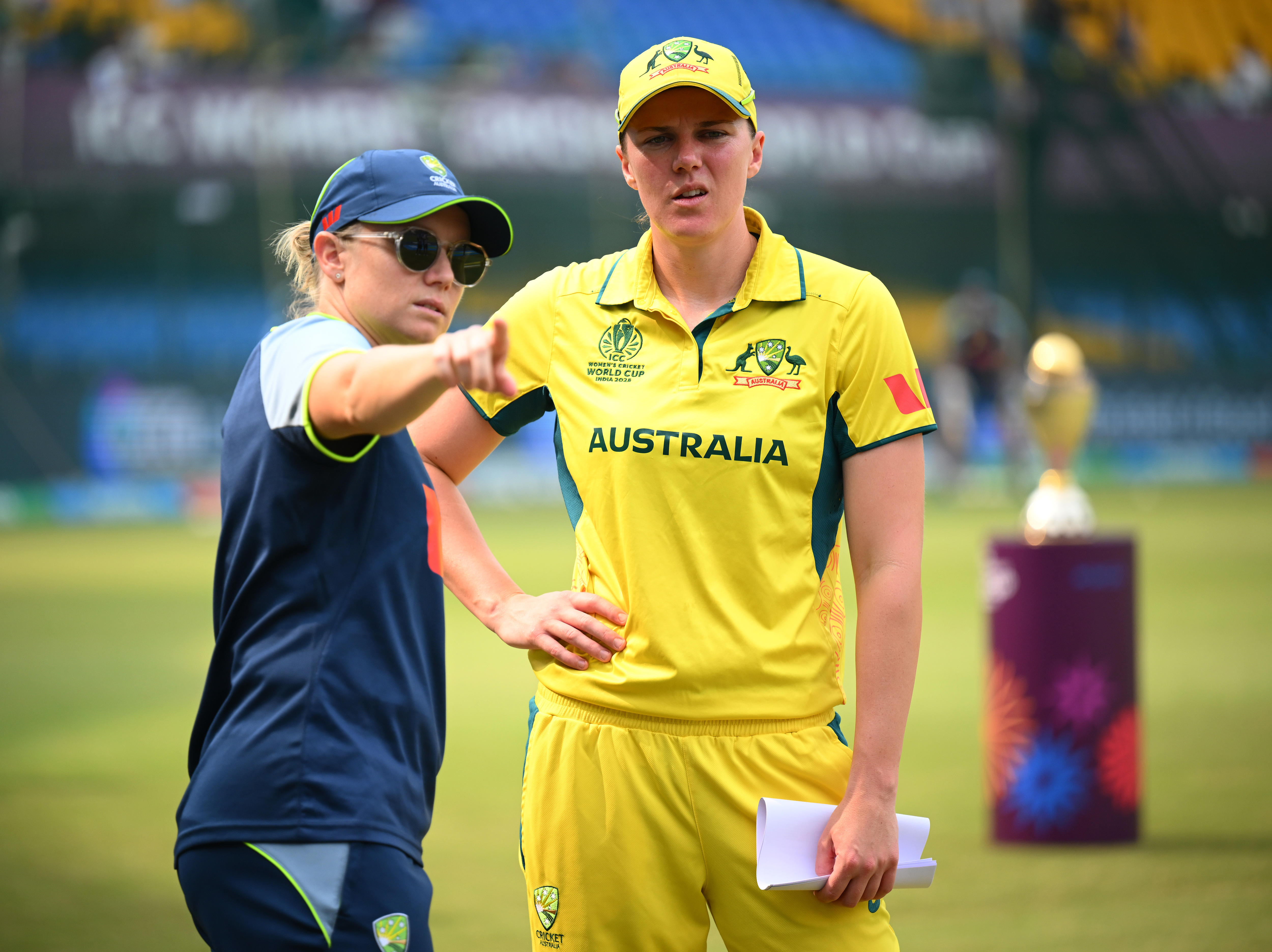 Alyssa Healy aponta enquanto a companheira de equipe Tahlia McGrath observa.