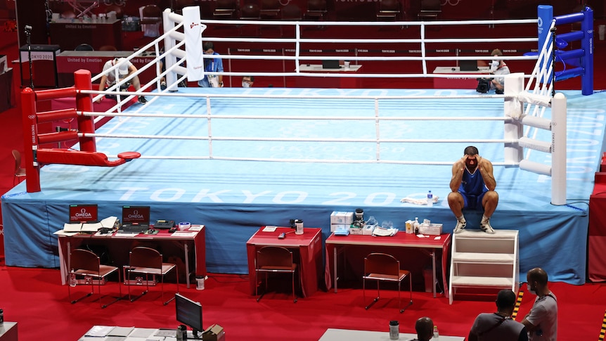 A French boxer sits on the outside of the ring in protest after being disqualified.
