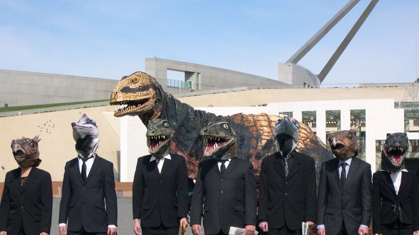 Environmental activists dressed as dinosaurs call for more clean green jobs to be created