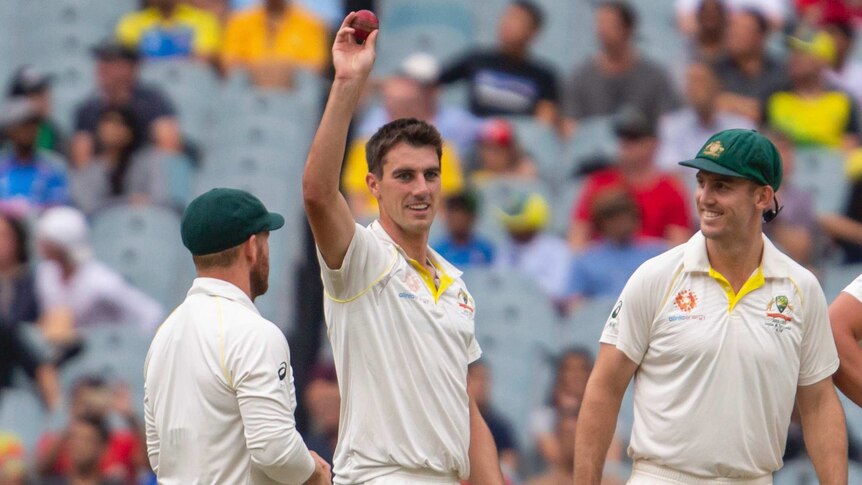 Pat Cummins raises the ball after getting his fifth wicket for Australia on day four at the MCG.