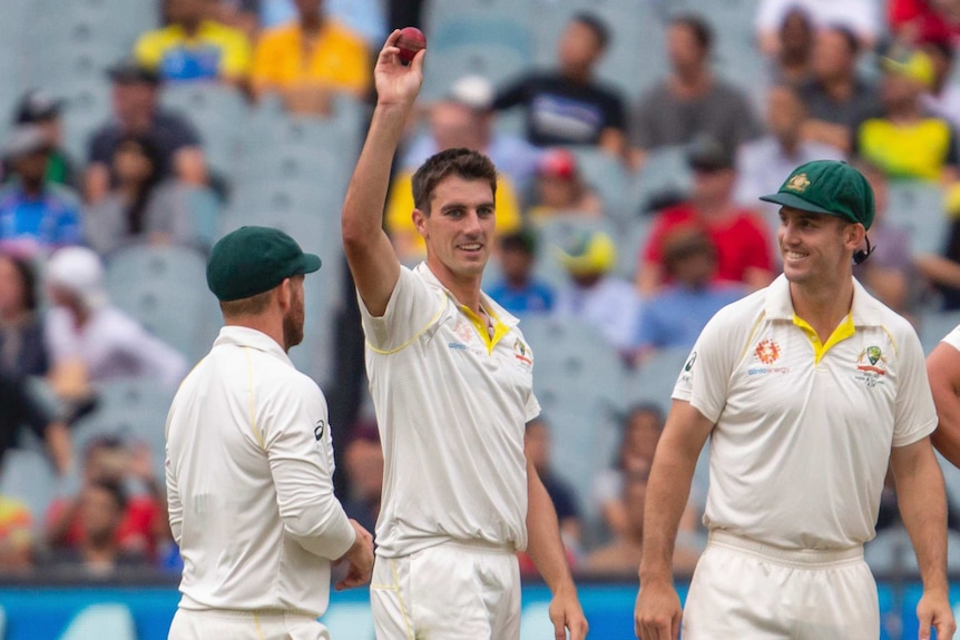 Pat Cummins raises the ball after getting his fifth wicket for Australia on day four at the MCG.