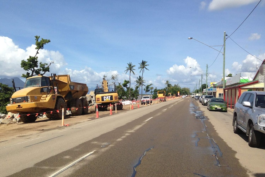 Construction work on a palm tree-lined foreshore