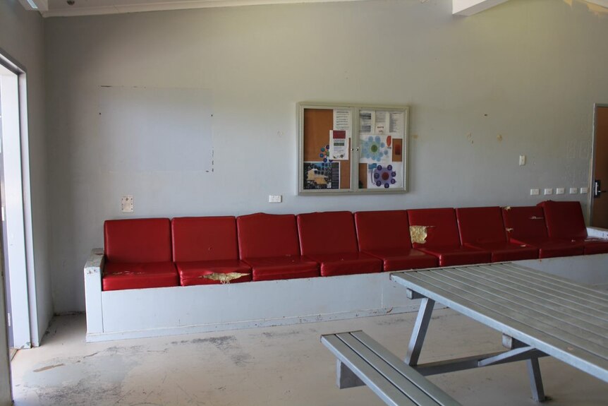 Damaged red seats inside a worn down youth justice centre in Alice Springs
