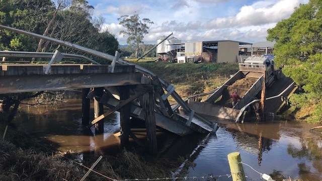 A collapsed bridge, with a truck almost all the way across.