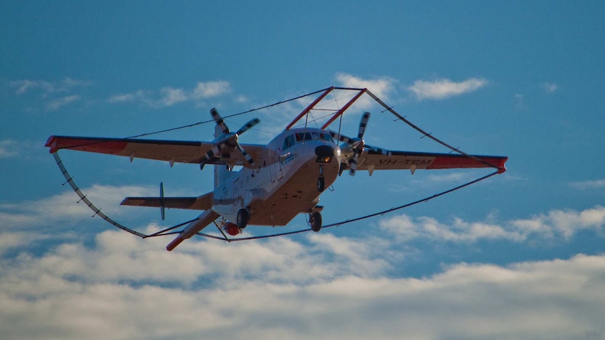 Image of an aircraft, covered in additional survey antennas, coming in to land.