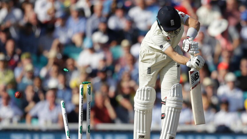 England batsman Joe Root is midway through his shot as the bal smashes into his stumps, sending bails flying.