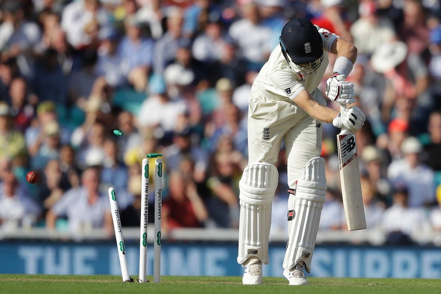 England batsman Joe Root is midway through his shot as the bal smashes into his stumps, sending bails flying.