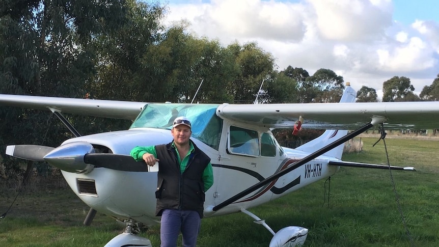 Pilot standing in front of Cessna light airplane.