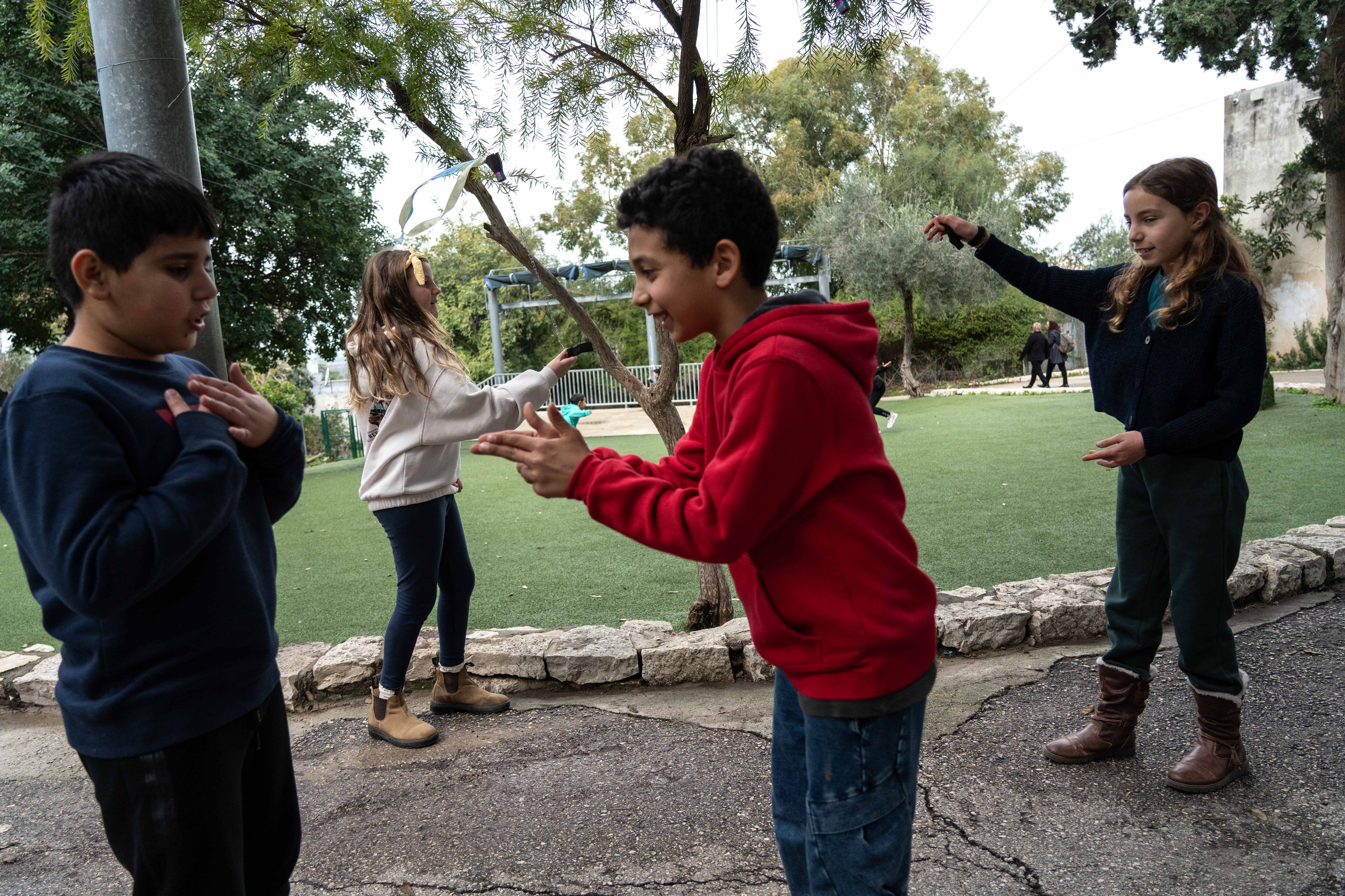 Two Palestinian boys play next to to Jewish girls at lunchtime in the school yard.