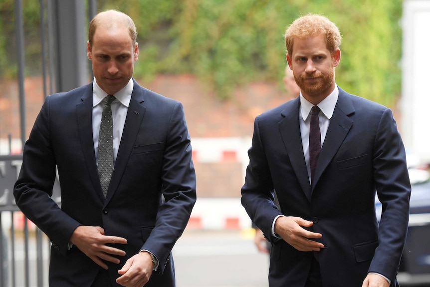 Britain's Prince William, left, and Prince Harry wearing dark coloured suits.