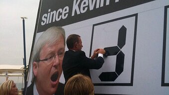 Opposition Leader Tony Abbott changes numbers on a billboard attacking the Federal Government's policy on asylum seeker boat ...