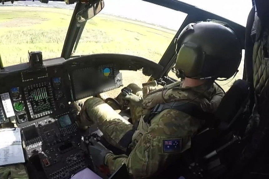 A pilot inside the cockpit of an Army Chinook helicopter