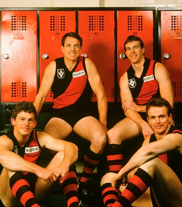 Quatro homens com uniformes do Essendon Football Club.