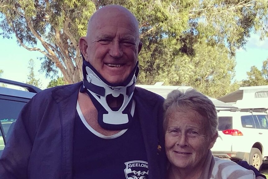 Older man with neckbrace standing with woman
