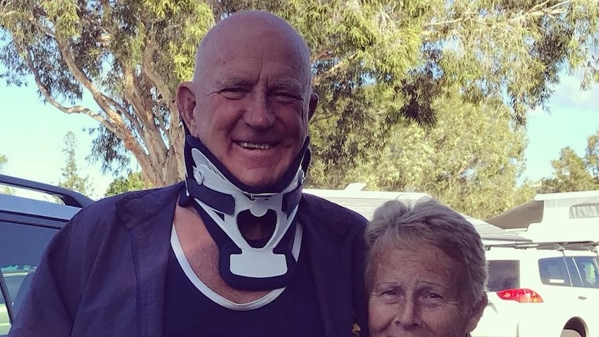 Older man with neckbrace standing with woman
