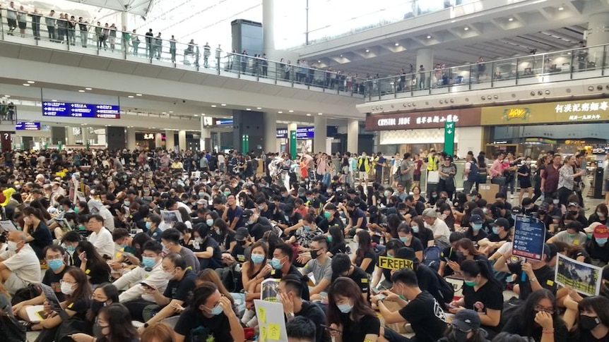 Protestors stage a peaceful demonstration in the arrivals hall at HK airport