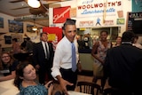 Barack Obama and Michelle Obama greet people as they arrive to have lunch at a bakery