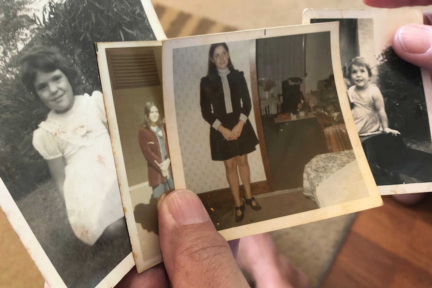 Diane Lynn holding old photos of herself.