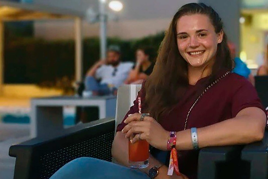 Saskia Jones sits in a chair and smiles