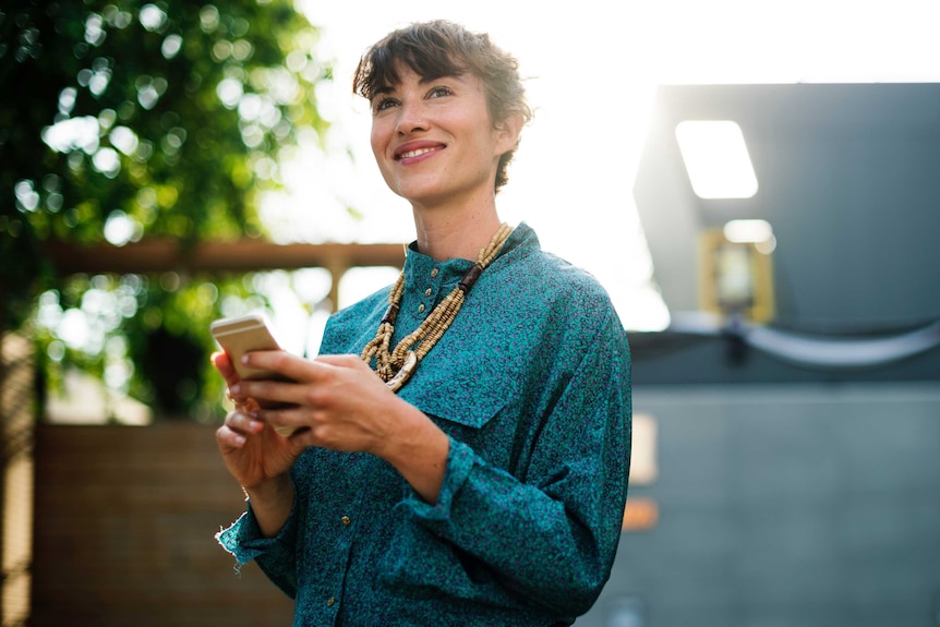 Smiling woman holding a smartphone