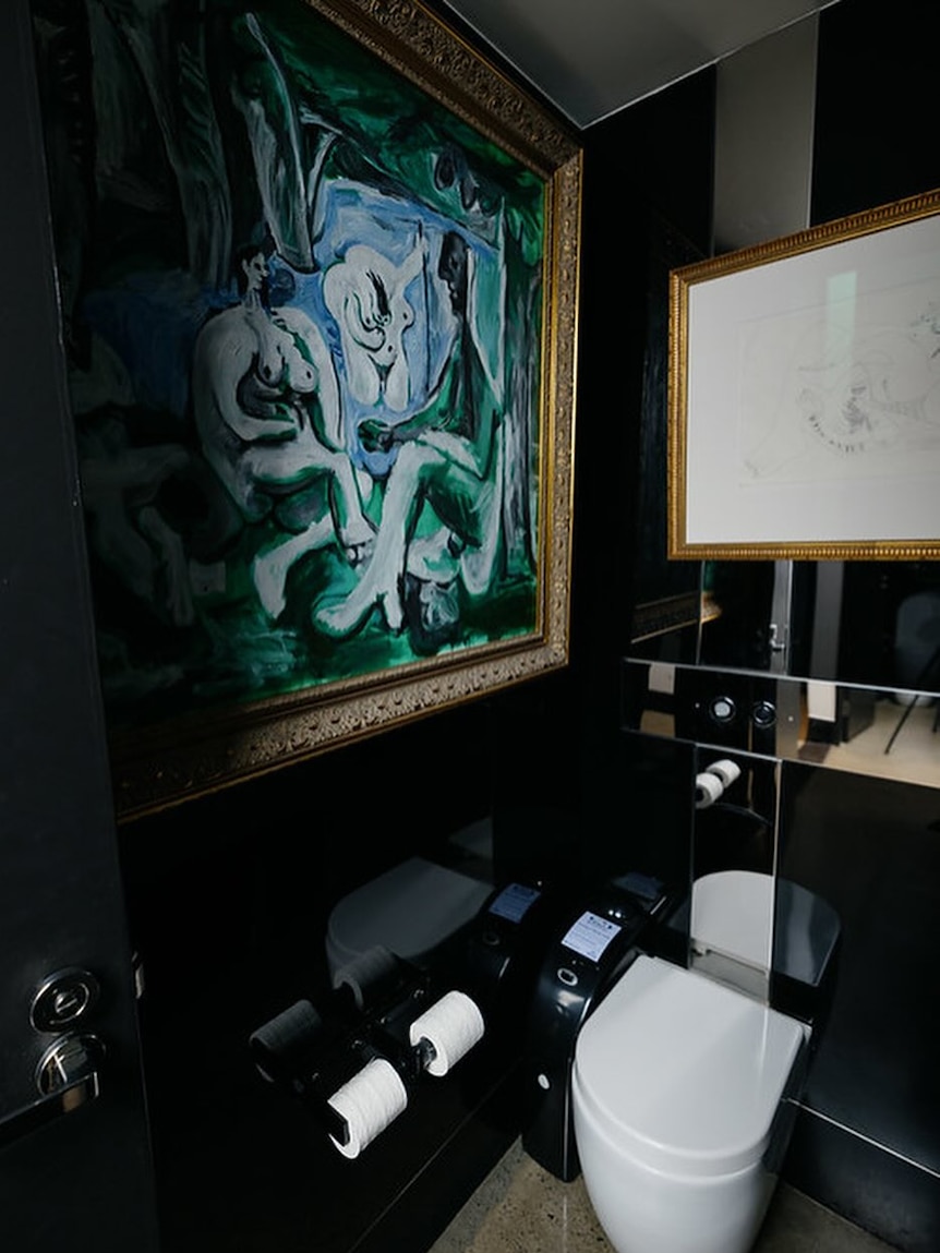 Picasso painting hanging in a toilet.