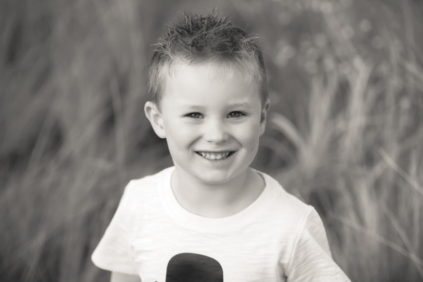 A black and white photograph of a young boy