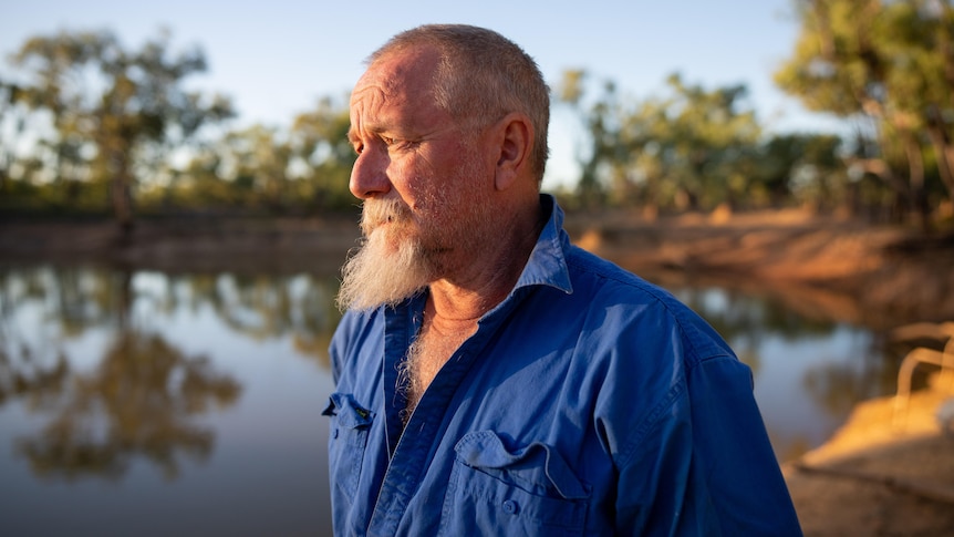A middle-aged pastoralist looks with concern over a body of water at Gorrie Station.