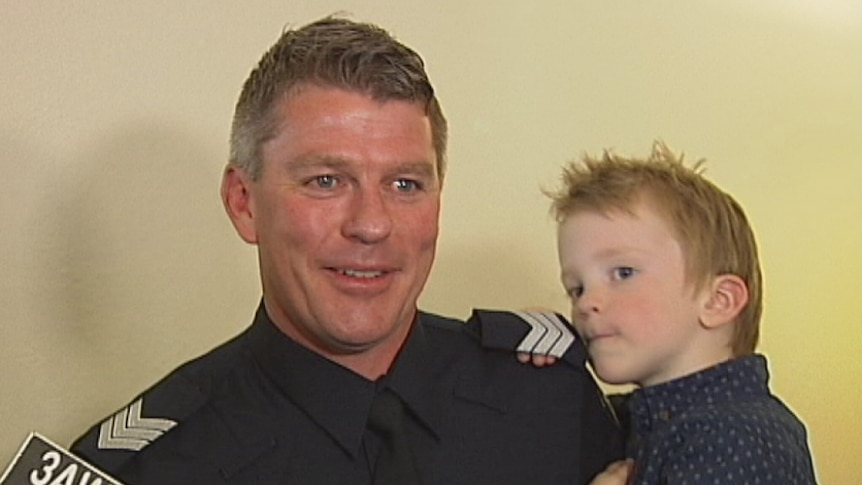 Sergeant Daniel Burgess was awarded for bravery after he leapt into the sea to rescue a drowning fisherman.