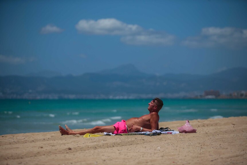 A German tourist sunbathes on the beach of Palma de Mallorca.