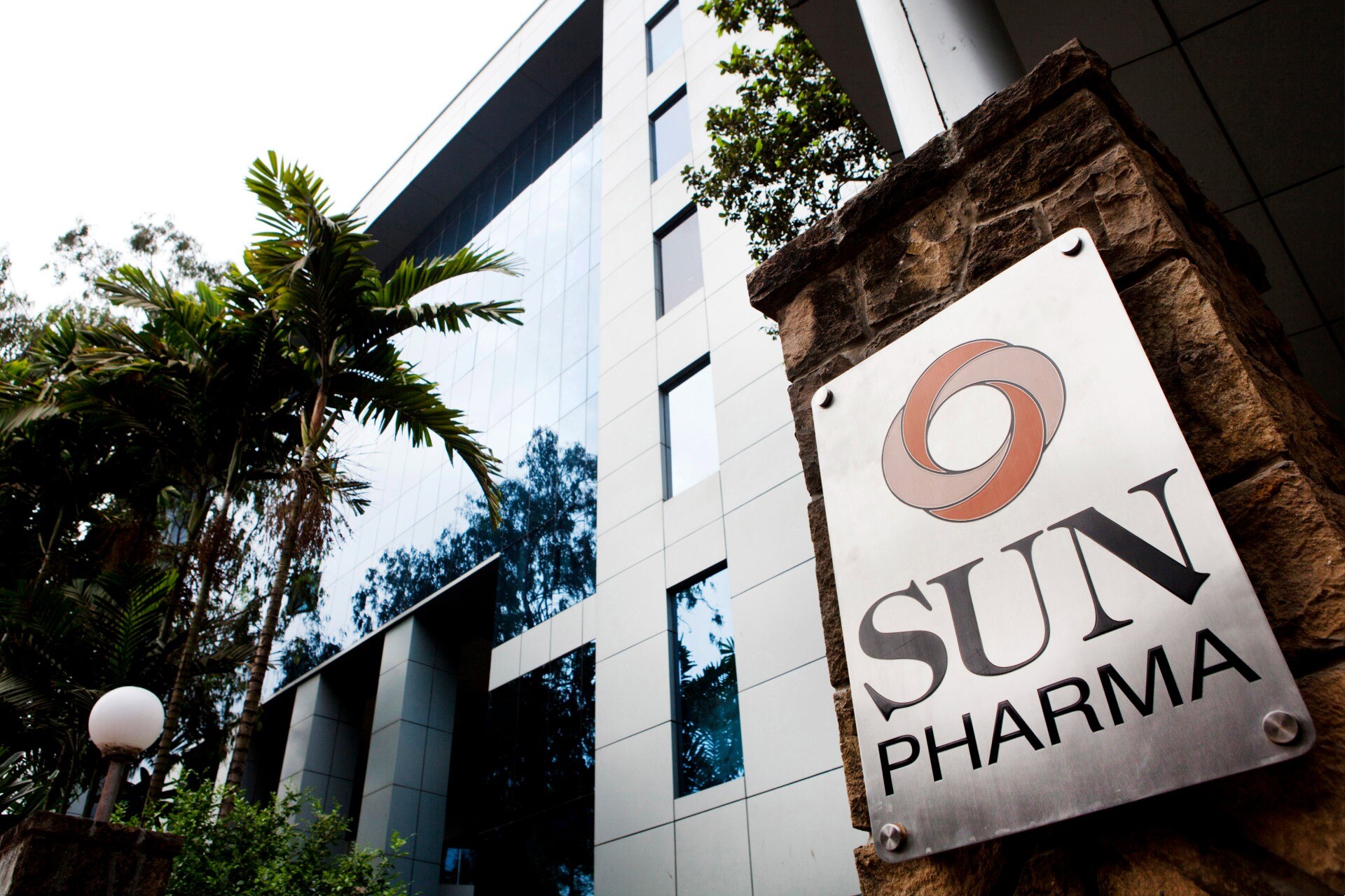 A sign reading Sun Pharma outside a tall building