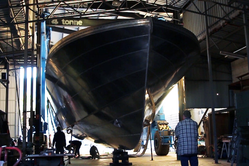 A cray fish boat hull inside it's Geraldton workshop