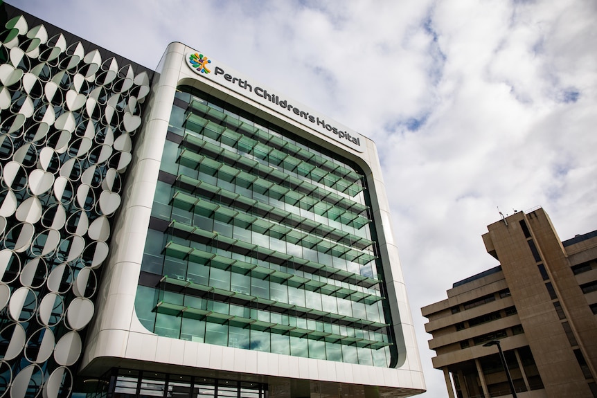 A wide shot of a building with the words Perth Children's Hospital on top, with a cloudy sky in the background.