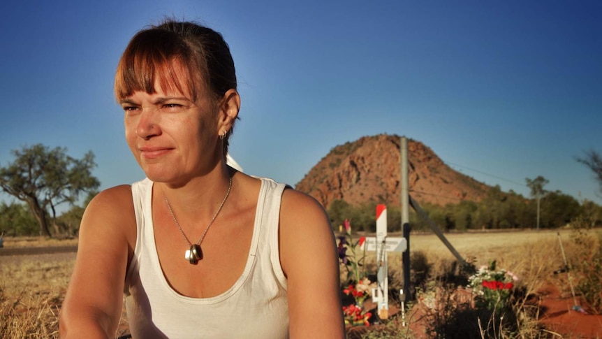 Judith Kuerschner, the wife of Michael Pederson, sits in front of a memorial in Alice Springs