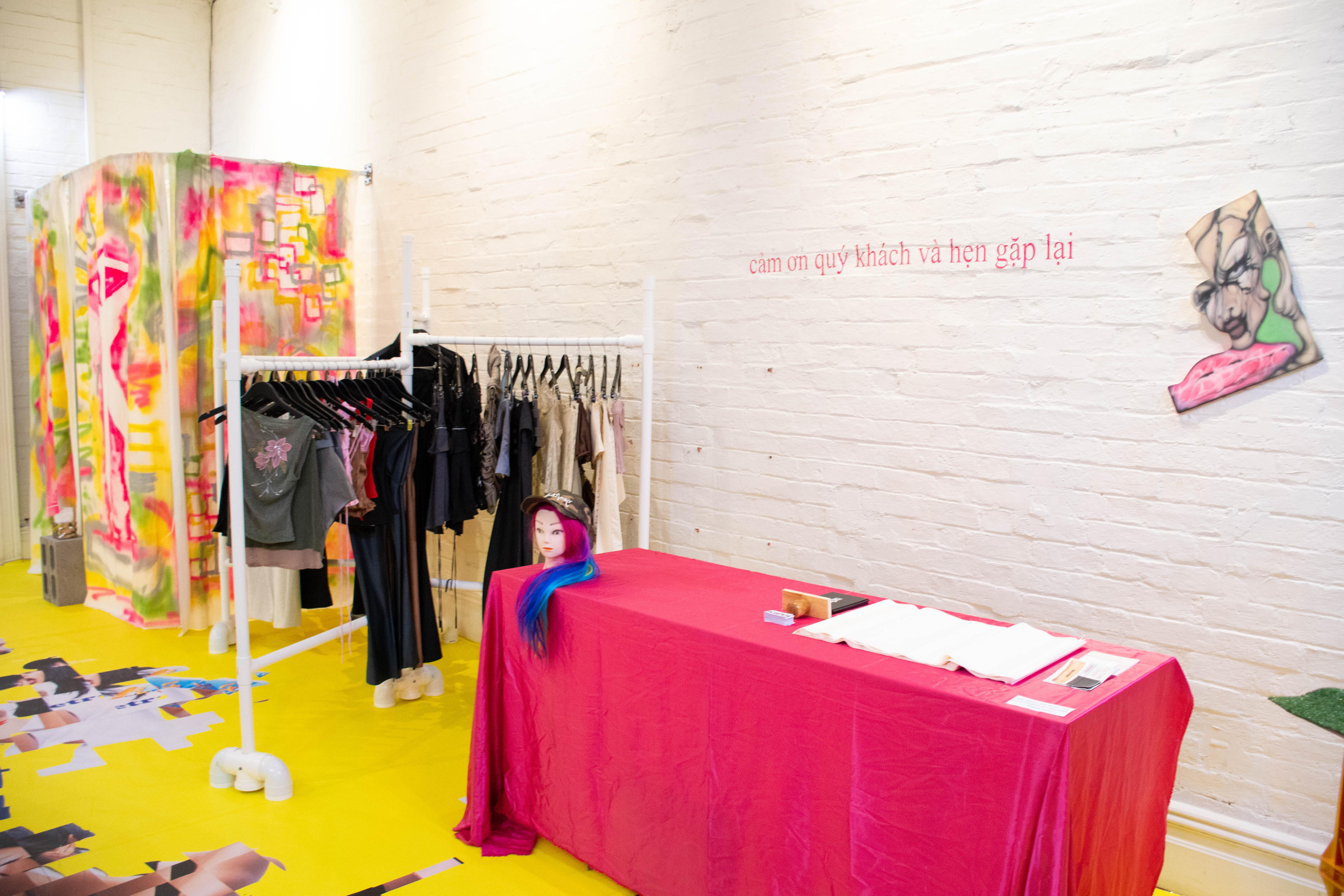 El interior de la tienda pop-up de una tienda de moda independiente con suelos coloridos, un perchero y un vestuario. 